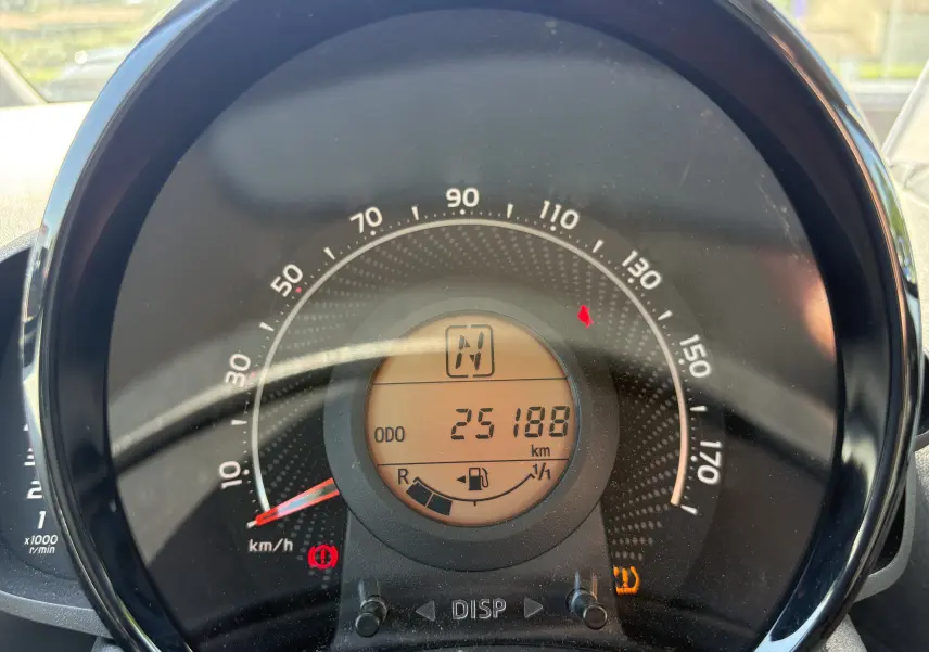 Vue rapprochée du compteur de vitesse circulaire de la Toyota Aygo MC 2020, affichant 25 188 km et témoins allumés.