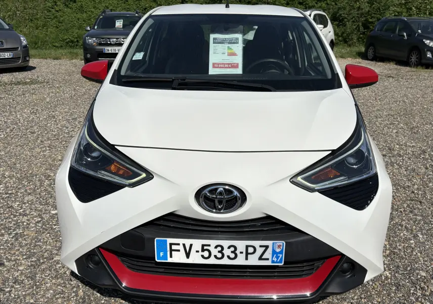 Vue avant d'une Toyota Aygo MC blanche 2020 avec rétroviseurs rouges et détails rouges sur le pare-chocs.