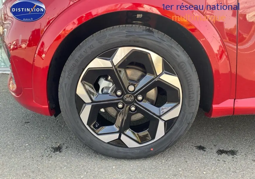 Gros plan sur la roue avant droite avec jante alu noire et argentée du Ford Puma rouge Fantastic Métallisée.