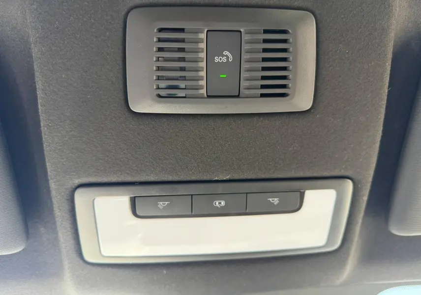 Vue en contre-plongée du plafonnier noir avec bouton SOS et commandes d'éclairage blanc dans un MG MOTOR MG3 2025 hybride.