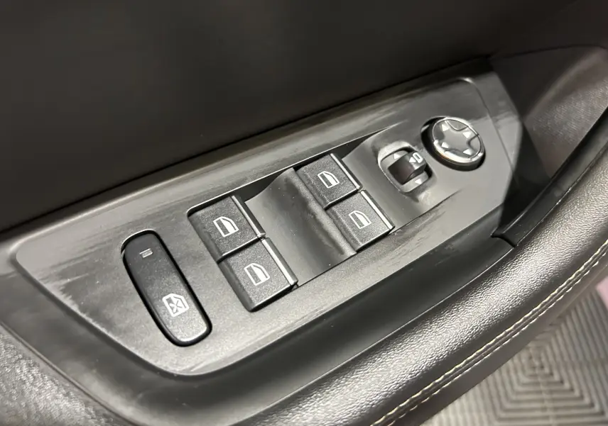 Gros plan sur les commandes de lève-vitres et rétroviseurs côté conducteur du Peugeot 508 SW gris Artense 2024.