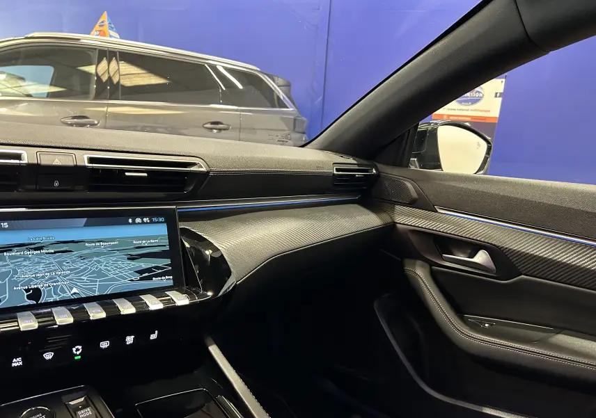 Intérieur côté passager du Peugeot 508 SW 2024 gris artense, avec tableau de bord moderne et écran tactile GPS allumé.