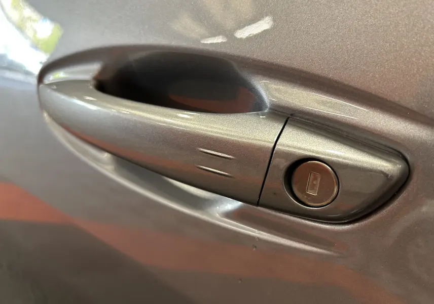 Poignée de porte gris artense en gros plan sur Peugeot 508 SW BlueHDi 130 EAT8 GT avec serrure intégrée.