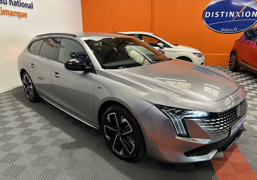 Peugeot 508 SW BlueHDi 130 GT gris artense en 3/4 avant droit avec phares LED et jantes noires bicolores.