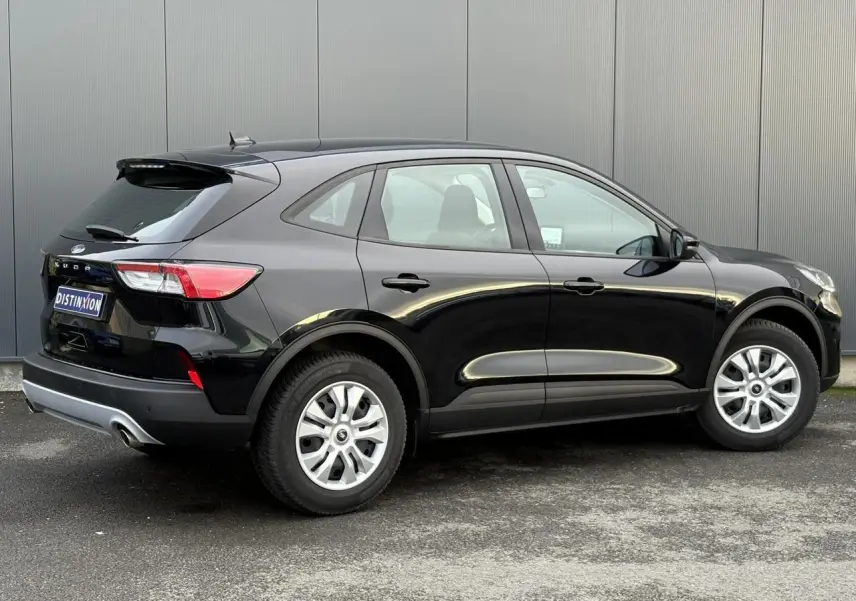 Vue 3/4 arrière droite d'un Ford Kuga 2024 noir obsidien avec jantes argentées et feux arrière allongés.