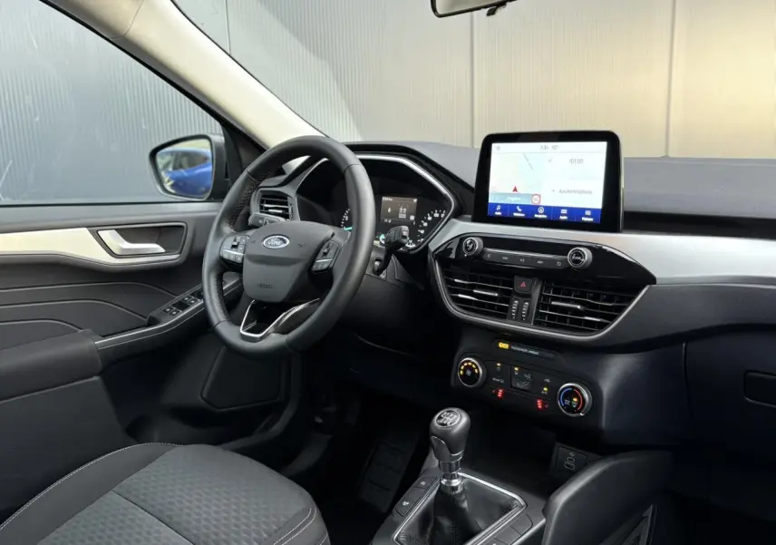 Vue intérieure côté conducteur du Ford Kuga 2024 noir Obsidien, avec tableau de bord moderne et écran tactile central.