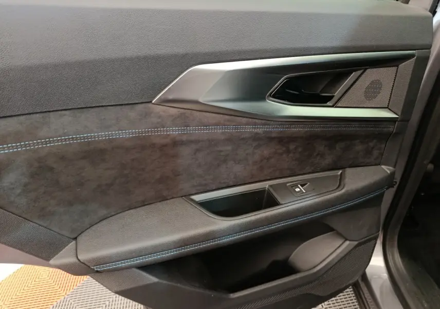 Détail de la porte avant droite du Renault Austral gris clair, avec surpiqûres bleues et insert aluminium.
