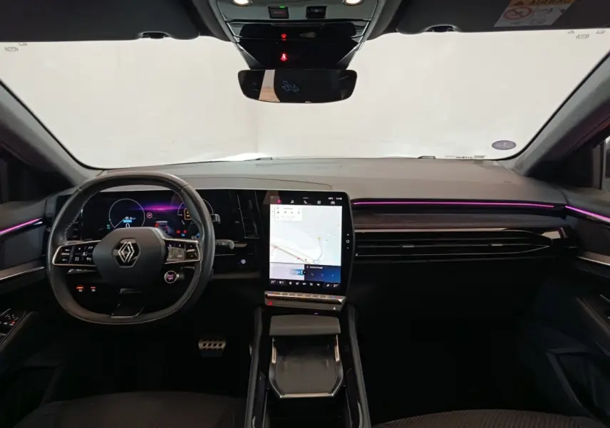Vue intérieure avant du Renault Austral gris clair 2024, tableau de bord avec écran tactile vertical et éclairage d'ambiance violet.