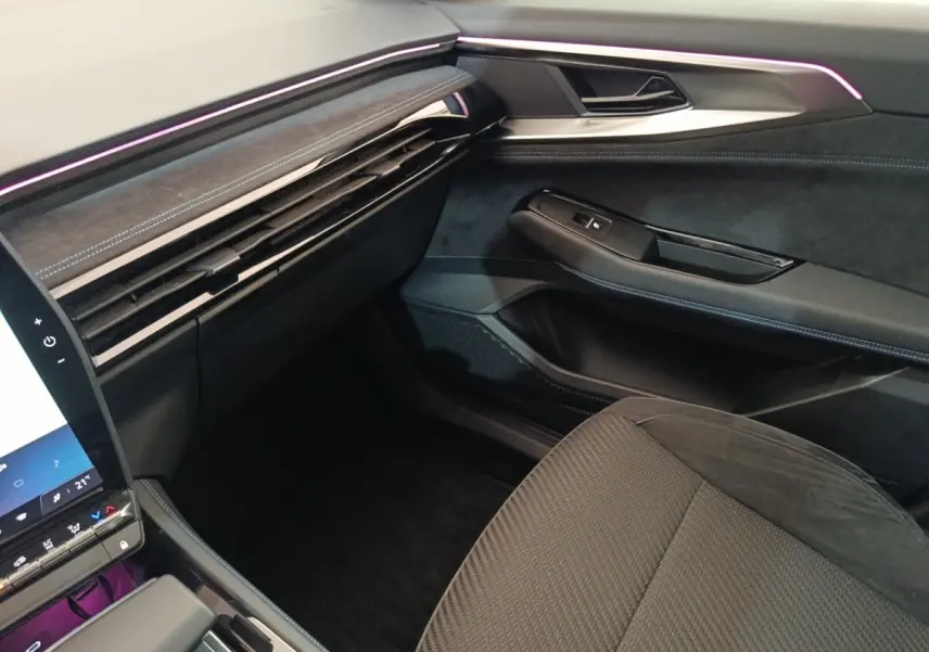 Vue intérieure côté passager du tableau de bord et porte avec éclairage d'ambiance violet du Renault Austral Iconic Esprit Alpine.