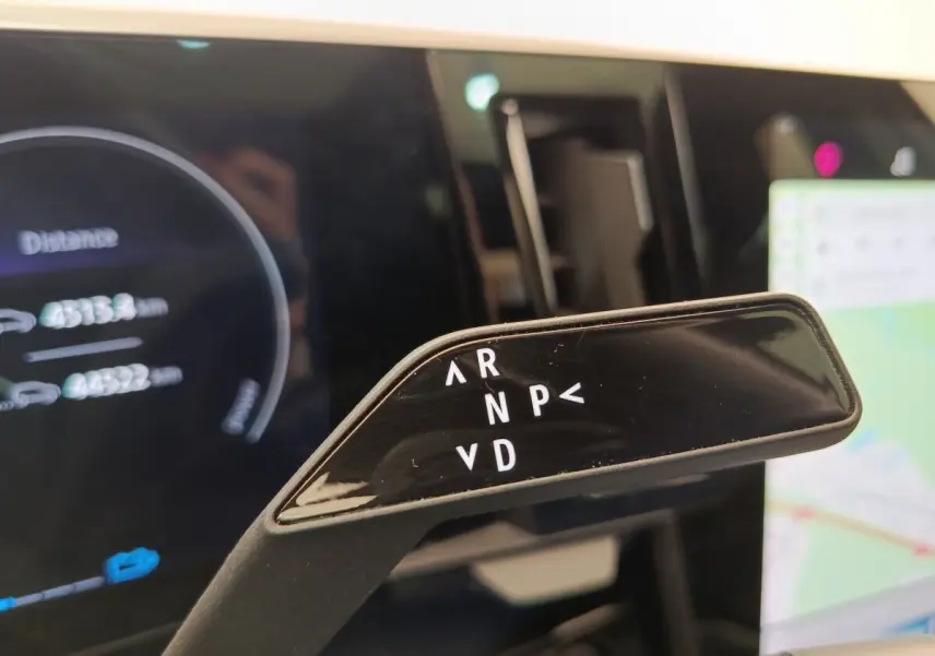 Gros plan sur la commande de boîte automatique noire du Renault Austral gris clair, avec affichage digital en arrière-plan.