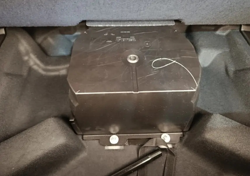 Vue rapprochée du compartiment de coffre du Renault Austral gris clair, montrant un boîtier noir central.