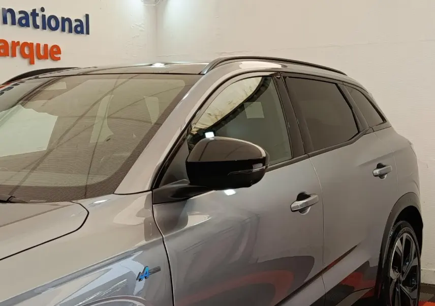 Vue de profil droit du Renault Austral gris clair Iconic Esprit Alpine E-Tech 2024 avec logo Alpine bleu sur l'aile avant.
