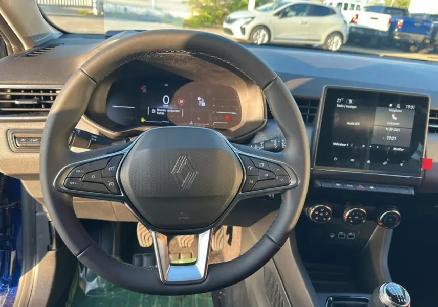 Vue intérieure du volant et tableau de bord de la Renault Clio DCI 100 Evolution Camera 2025 en bleu iron, avec boîte manuelle.