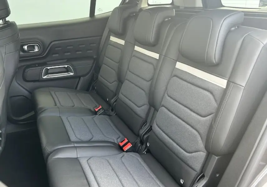 Vue intérieure des trois sièges arrière indépendants en cuir et tissu gris du Citroën C5 Aircross 2025.