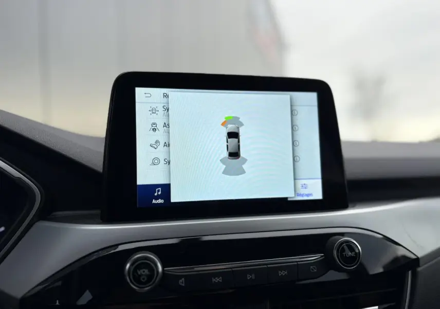 Écran tactile central du Ford Kuga 2024 affichant l’aide au stationnement, vue intérieure du tableau de bord.