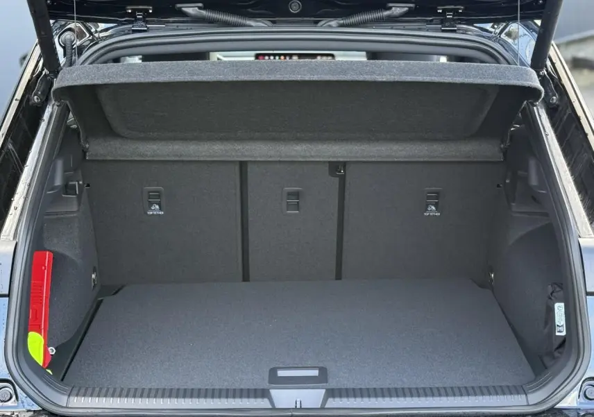 Coffre ouvert d'un Volkswagen T-Roc noir ébène, vue arrière montrant l'espace de chargement vide et la trappe supérieure.