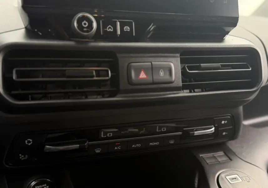 Gros plan sur la console centrale du Peugeot Rifter vert Sirkka 2026, montrant les commandes de climatisation et les aérateurs.