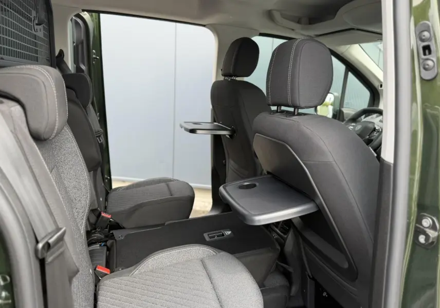 Vue intérieure côté droit du Peugeot Rifter Vert Sirkka 2026 avec sièges individuels et tablettes rabattables.