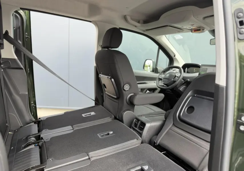 Vue intérieure côté droit du Peugeot Rifter Vert Sirkka 2026, sièges arrière rabattus et siège avant conducteur avec tablette.