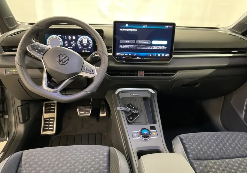 Vue intérieure avant du Volkswagen T-Roc 2026, tableau de bord noir avec volant sport multifonction et écran tactile central.