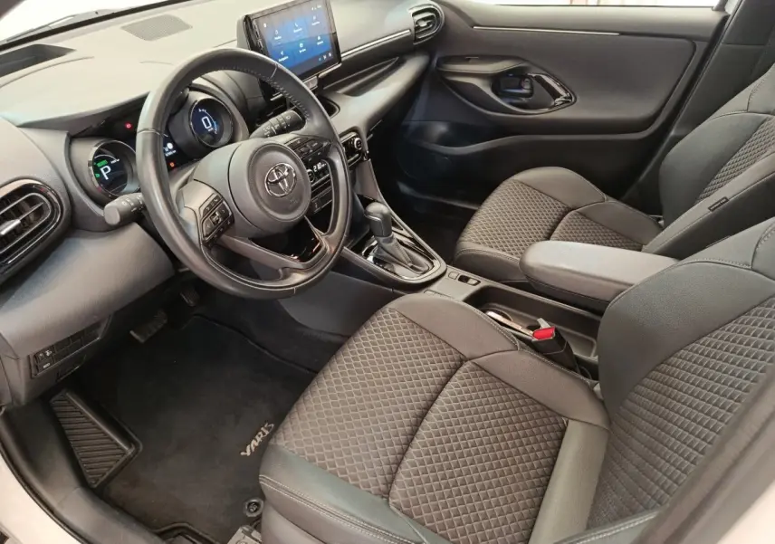 Vue intérieure côté conducteur de la Toyota Yaris Hybride 116h Collection 2022 avec écran tactile et sièges tissu gris.