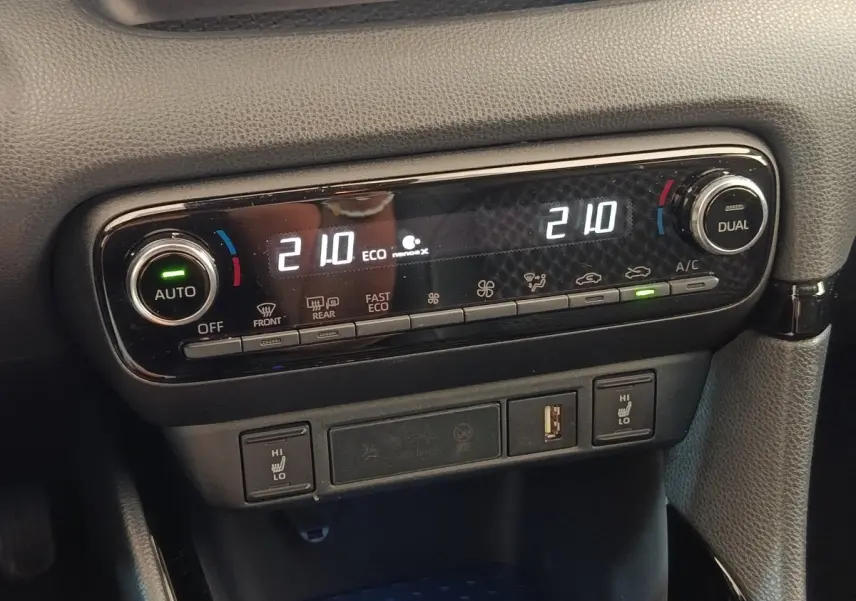 Gros plan sur la commande de climatisation automatique bi-zone avec affichage digital et réglages de température à 21°C.