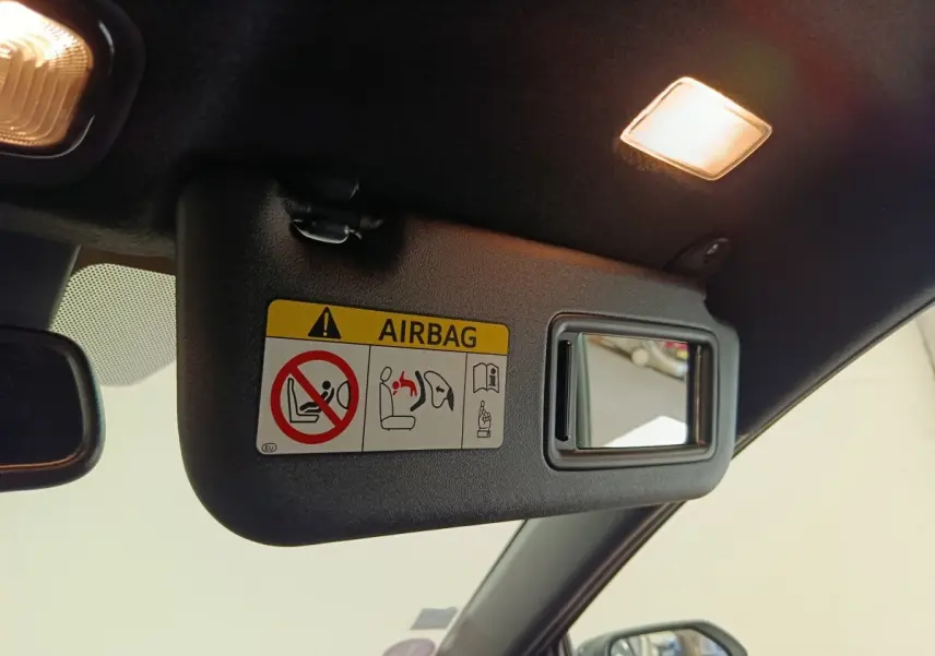 Détail du pare-soleil côté conducteur avec miroir et avertissement airbag dans une Toyota Yaris blanche 2022.