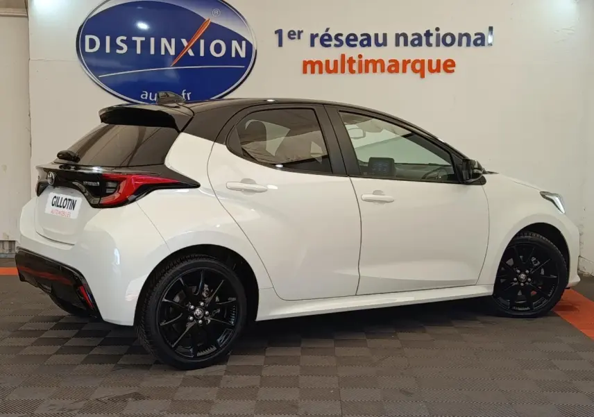 Toyota Yaris Hybride 116h Collection blanche vue de profil droit, toit noir et jantes noires distinctives.