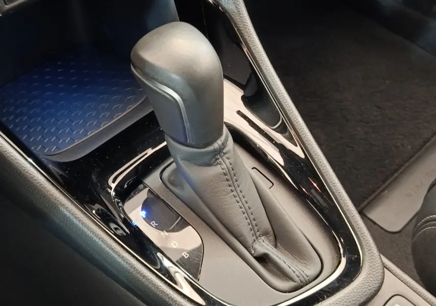 Le levier de vitesses automatique en cuir noir de la Toyota Yaris Hybride 116h, vue rapprochée de la console centrale.