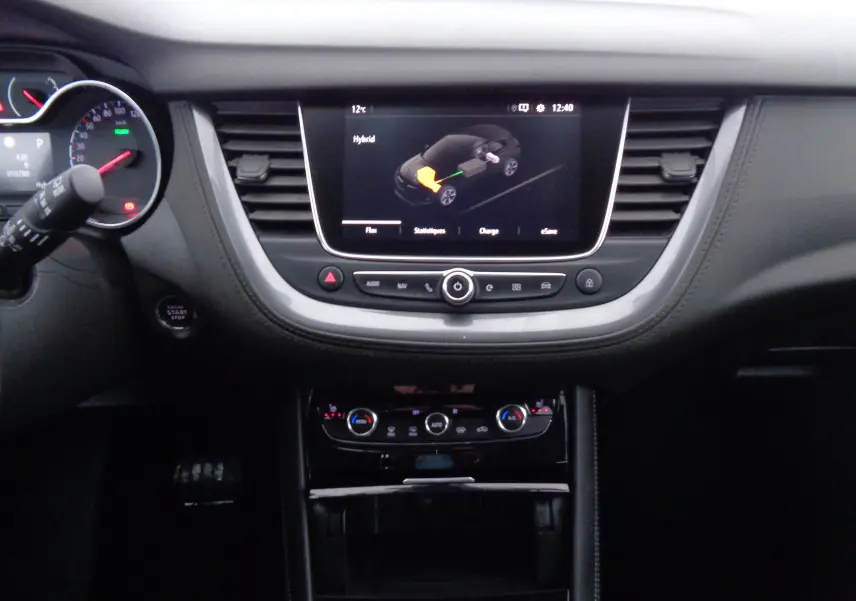 Tableau de bord noir de l'Opel Grandland X hybride 2021 avec écran tactile affichant le mode hybride.