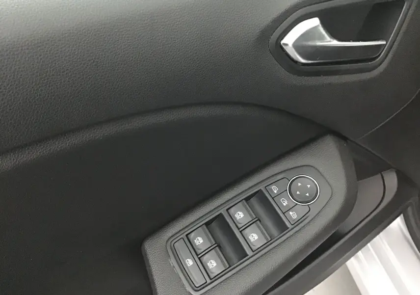 Panneau de porte côté gauche de la Renault Clio V gris platine, avec commandes électriques des vitres et poignée intérieure.