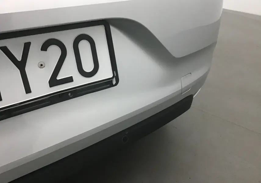 Gros plan sur le pare-chocs arrière gris platine d'une Renault Clio V 1.0 TCE 90 Zen avec plaque d'immatriculation partielle visible.