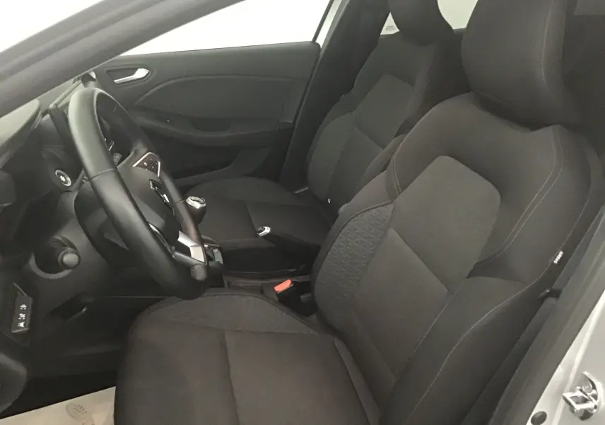 Vue intérieure côté conducteur de la Renault Clio V 1.0 TCE 90 Zen avec sièges tissu noir et volant multifonction.