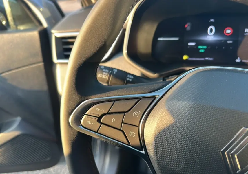 Gros plan sur le volant côté gauche de la Renault Clio gris rafale 2025, avec commandes de régulateur de vitesse.