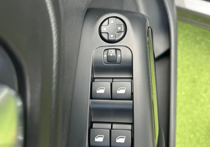 Gros plan sur les commandes de réglage des rétroviseurs et des vitres côté conducteur d'une Citroën C5 Aircross gris platinium.