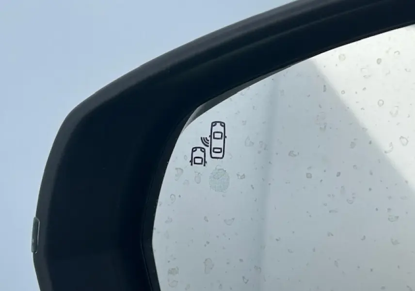 Gros plan sur le rétroviseur extérieur noir brillant du Citroën C5 Aircross gris platinium avec icône d'alerte d'angle mort.