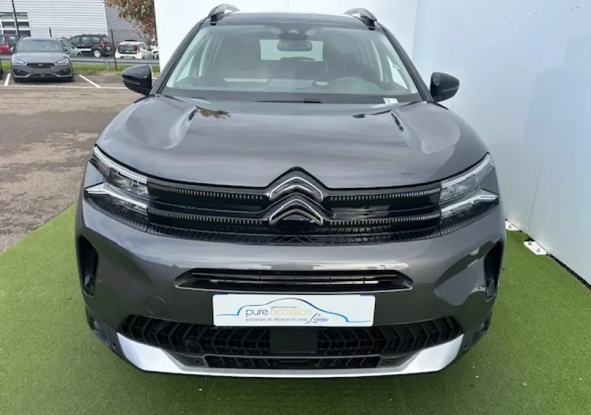 Vue frontale d'un Citroën C5 Aircross gris platinium métallisé avec calandre noir brillant et chevrons chromés.