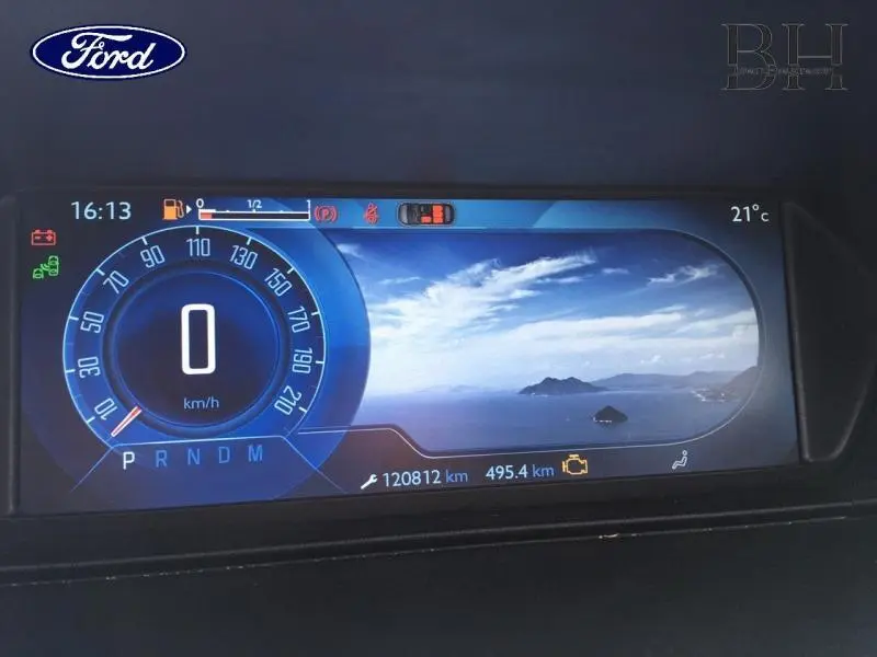 Tableau de bord numérique de Ford avec compteur digital bleu et affichage d'une vue maritime sur écran central.
