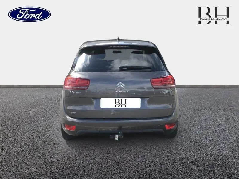 Vue arrière d'une Citroën C4 Picasso gris Shark avec attelage et vitres arrière teintées.