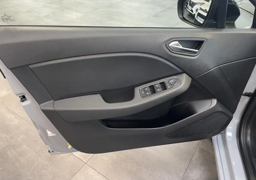 Porte avant gauche ouverte d'une Renault Clio 1.5 Blue dCi gris Rafale, avec commandes de vitres et rétroviseur visible.