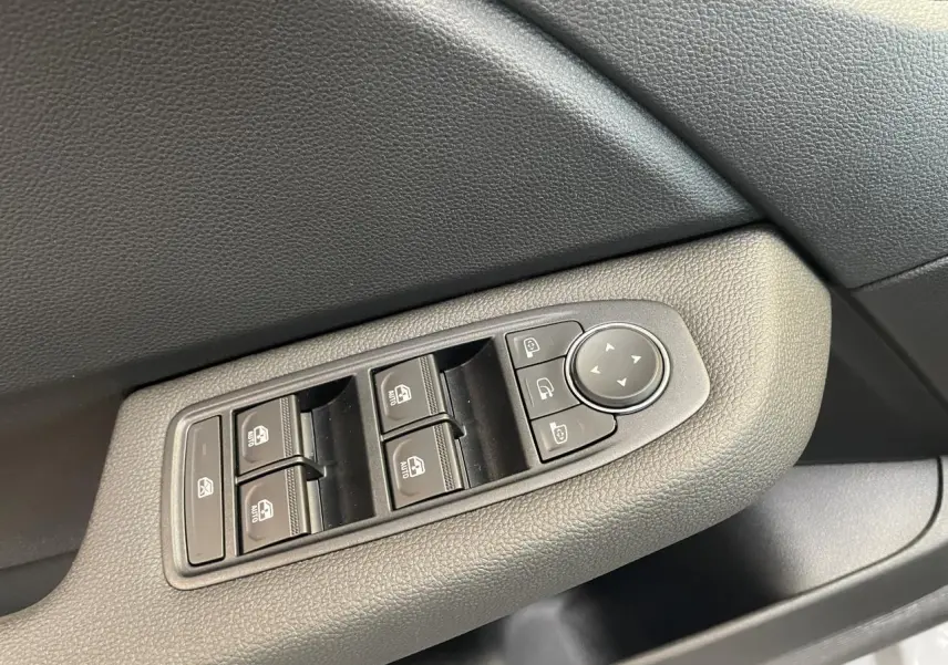 Commande des vitres électriques et réglage des rétroviseurs sur la porte côté gauche d'une Renault Clio gris Rafale.