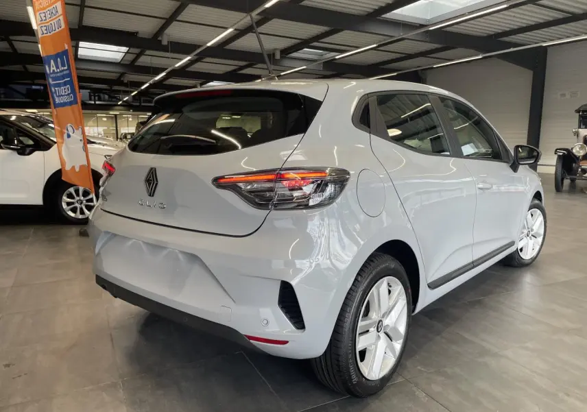 Vue 3/4 arrière droite d'une Renault Clio 2025 gris Rafale avec feux arrière LED et jantes alliage en showroom.