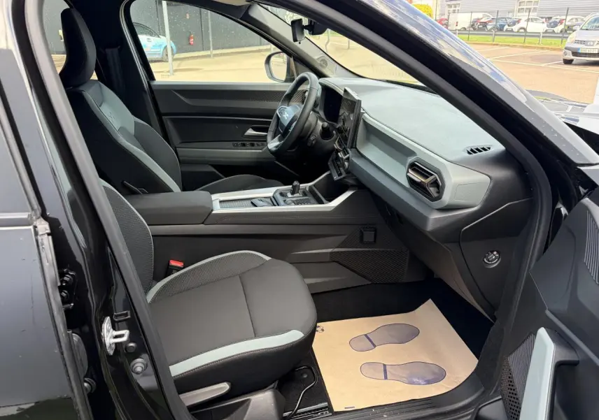 Vue intérieure côté conducteur du Dacia Bigster noir, mettant en valeur la sellerie et le tableau de bord moderne.