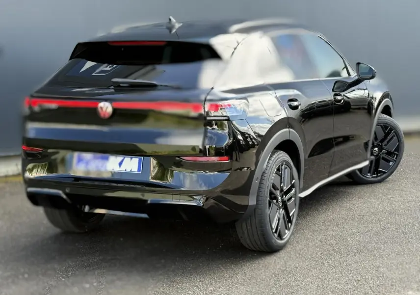 Volkswagen T-Roc noir ébène en 3/4 arrière droit, avec jantes noires sport et hayon électrique visible.