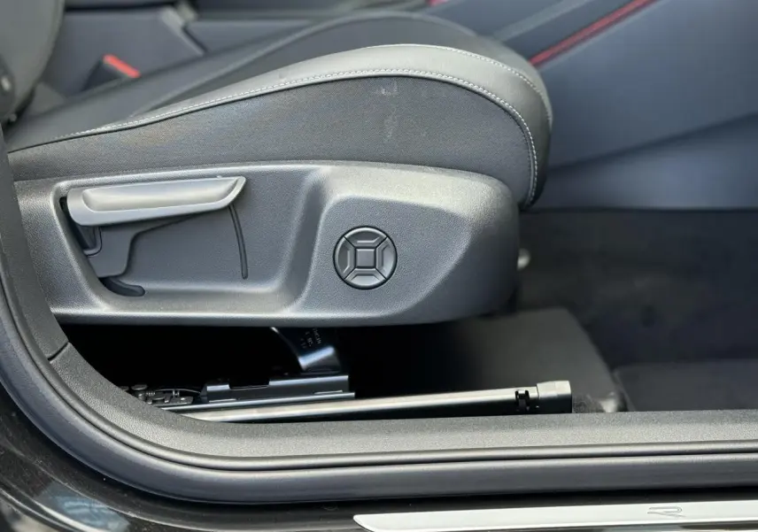 Détail du réglage manuel du siège avant côté gauche du Volkswagen T-Roc noir Ébène 2026 R-Line.