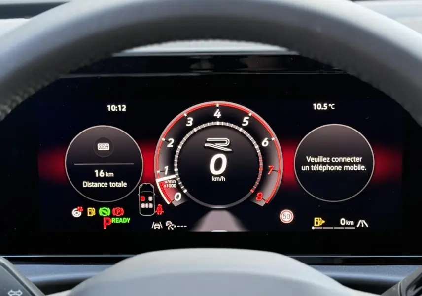 Vue rapprochée du tableau de bord numérique du Volkswagen T-Roc 2026, affichage R-Line avec fond noir et détails rouges.