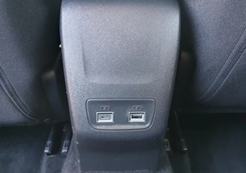 Prise USB type C et USB classique sur la console arrière d’une Peugeot 208 gris Artense, vue rapprochée intérieure.