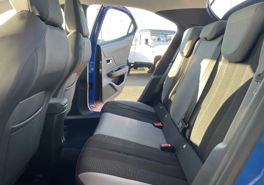 Vue intérieure côté gauche des sièges arrière noirs et gris du Opel Mokka bleu Voltak 2023 avec porte ouverte.