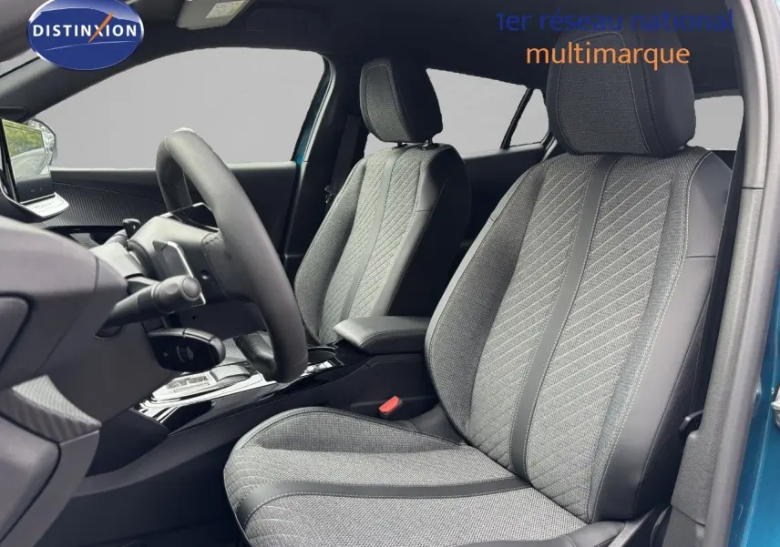Intérieur avant du Peugeot 2008 Hybrid 136ch Allure 2025 bleu obsession, sièges tissu et cuir noir avec coutures contrastées.