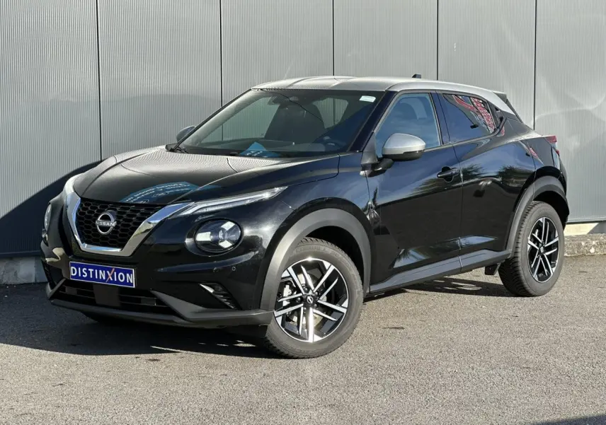 Nissan Juke noir métallisé en 3/4 avant droit, avec jantes alliage et calandre distinctive V-Motion.